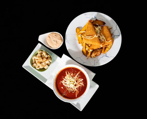 Vineri/Supă cremă de roșii cu crutoane (200 g) + Caș pane cu cartofi wedges și sos rose (500 g)