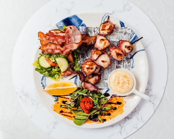 Caracatita pe frigaruie la gratar cu mix de salata, bacon afumat si sos aioli cu sofran