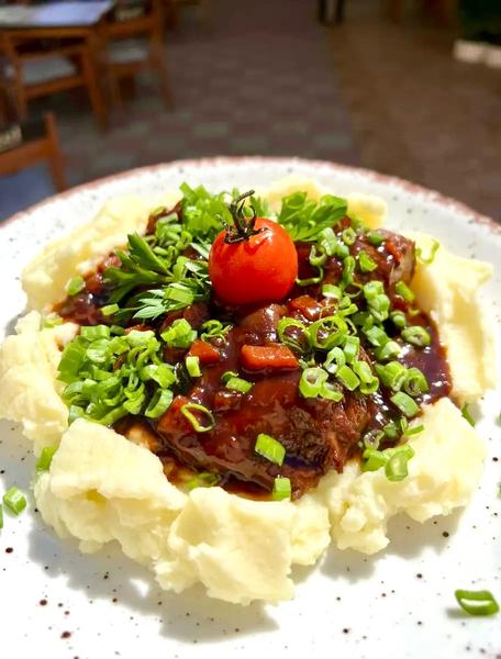 Obrajori de Porc Gatiti 12h in Sos Brun Spaniol, Serviti pe Pat de Puree de Cartofi