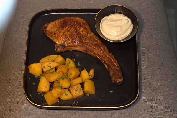 Tomahawk de porc cu sos gorgonzola și cartofi aurii