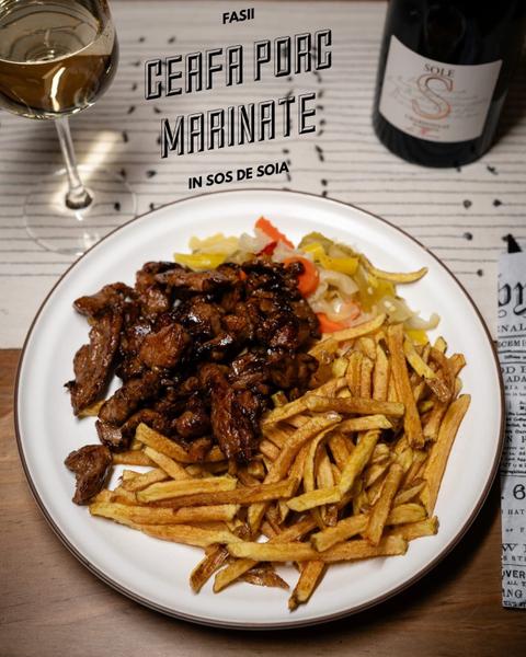 Fasii din ceafă de porc la tigaie marinate in sos de soia, servite cu cartofi prăjiți și salată de murături